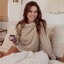 Woman holding jar of Arrae Sleep Supplement - A bottle of 60 capsules featuring a blend of natural ingredients, designed to promote restful sleep and relaxation without melatonin.