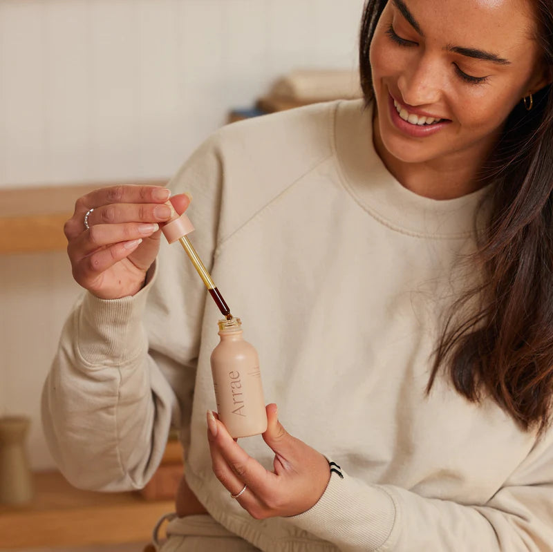 Woman squeezing Arrae Gut Boost tincture