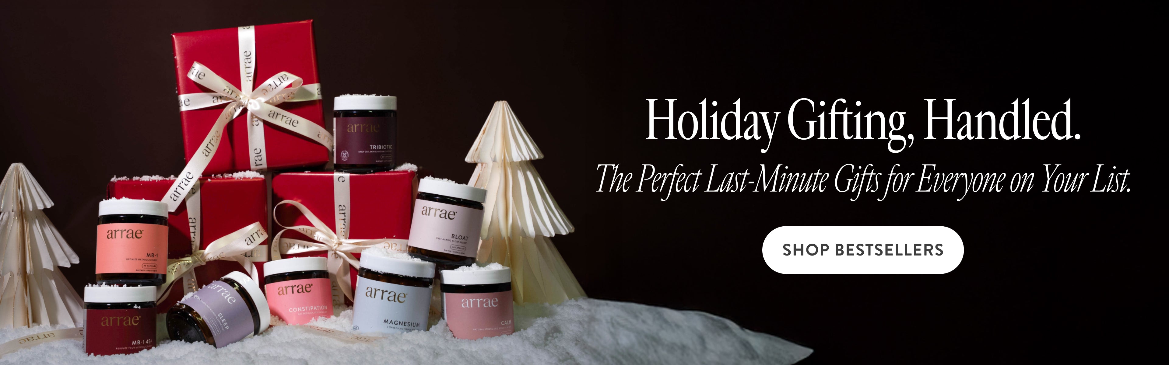 Holiday gift set with red boxes and small containers on a dark background with text about holiday gifting.