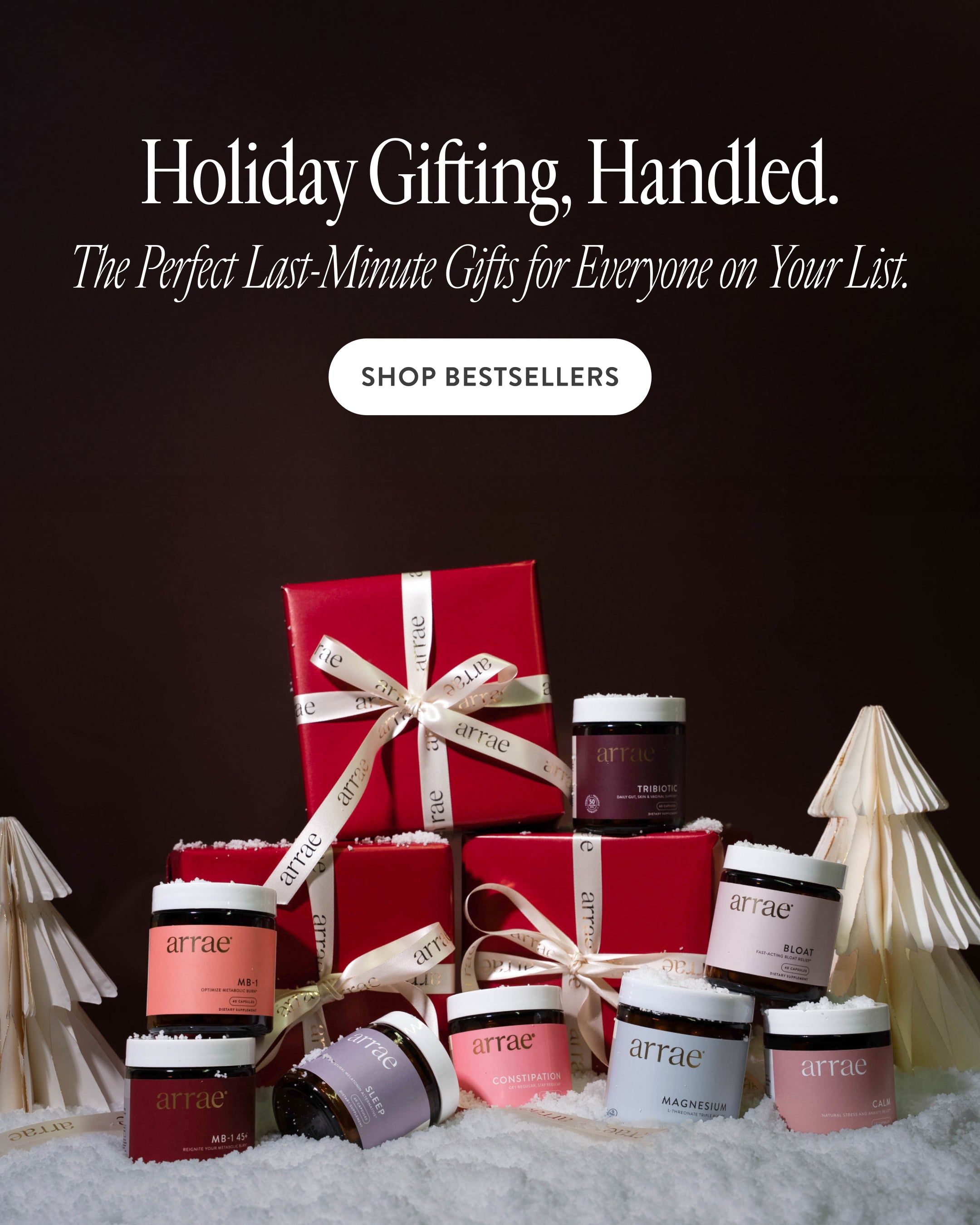 Holiday gift set with red boxes and skincare products on a snowy background, featuring the brand 'arrae'.