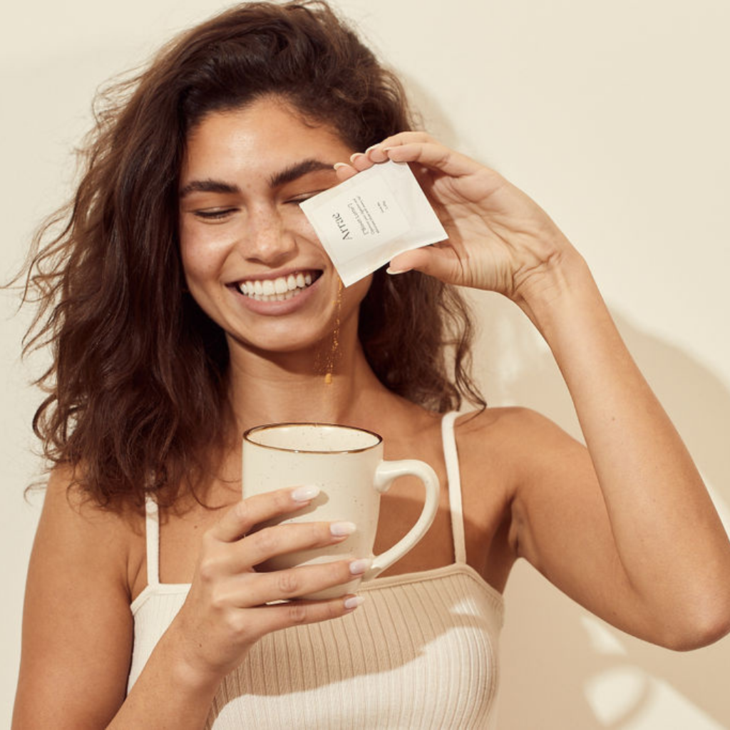 Woman pouring Arrae Bloat Latte sachet in mug