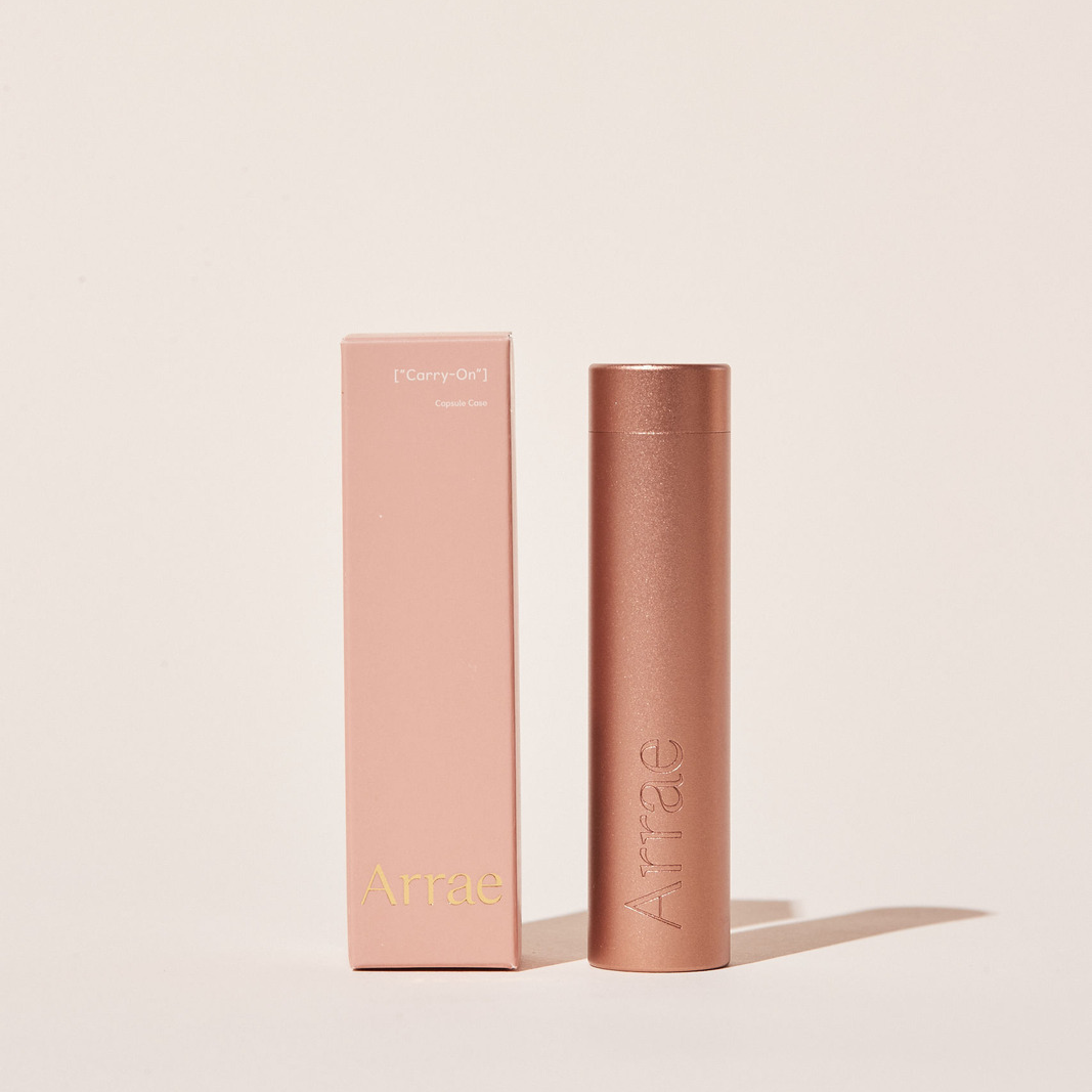 Arrae Carry-On Capsule Case Rosy Peach - A compact and durable tube-shaped travel case designed to store up to 10 Arrae Capsules.Arrae Carry-On Capsule Case - A compact and durable tube-shaped travel case designed to store up to 10 Arrae Capsules.