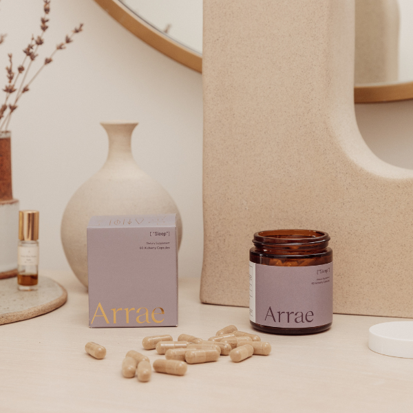 Arrae Sleep Supplement - A bottle of 60 capsules featuring a blend of natural ingredients, designed to promote restful sleep and relaxation without melatonin. The bottle is set next to the box and capsules on the table